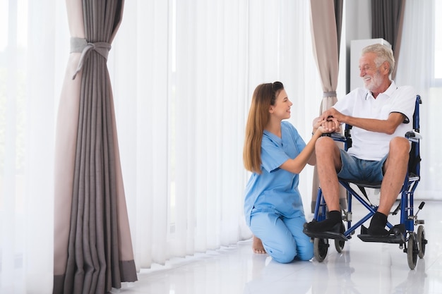 Foto enfermera feliz y anciano en silla de ruedas