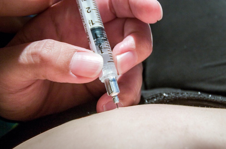 Foto la enfermera hace una inyección en el abdomen.
