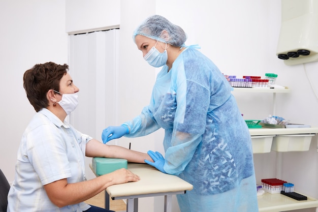 Enfermera haciendo análisis de sangre de la vena. Concepto de prueba de Covid