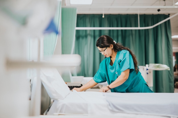 Enfermera haciendo la cama en un hospital.