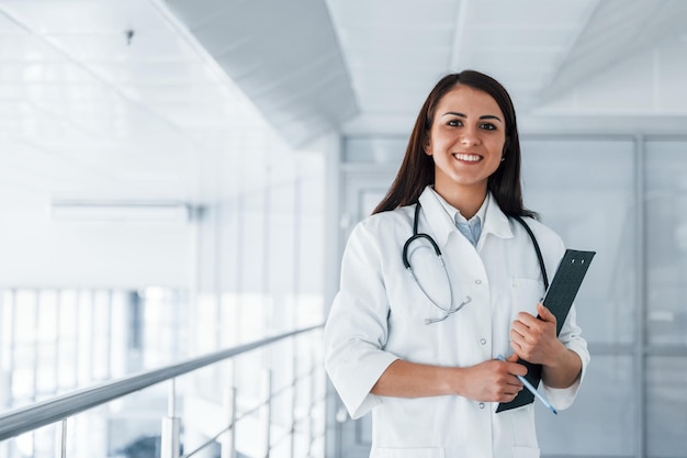 Enfermera joven y amable en el interior de una clínica moderna lista para ayudarte