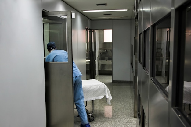 Enfermera llevando camilla de hospital a la sala de emergencias