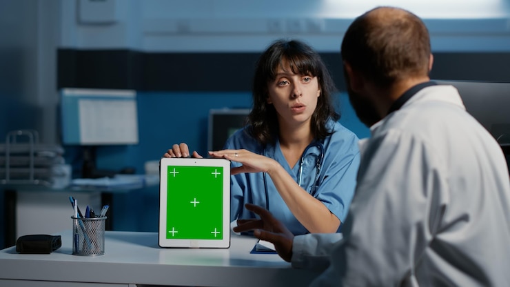 Foto enfermera médica sosteniendo una tableta apuntando a la pantalla verde mientras discute el diagnóstico del paciente con el médico, trabajando durante horas en el tratamiento de atención médica en la oficina del hospital. servicio de medicina