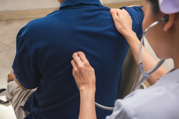 Foto enfermera médico cheques hombre paciente con estetoscopio