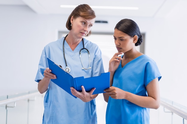 Enfermera y médico discutiendo sobre portapapeles