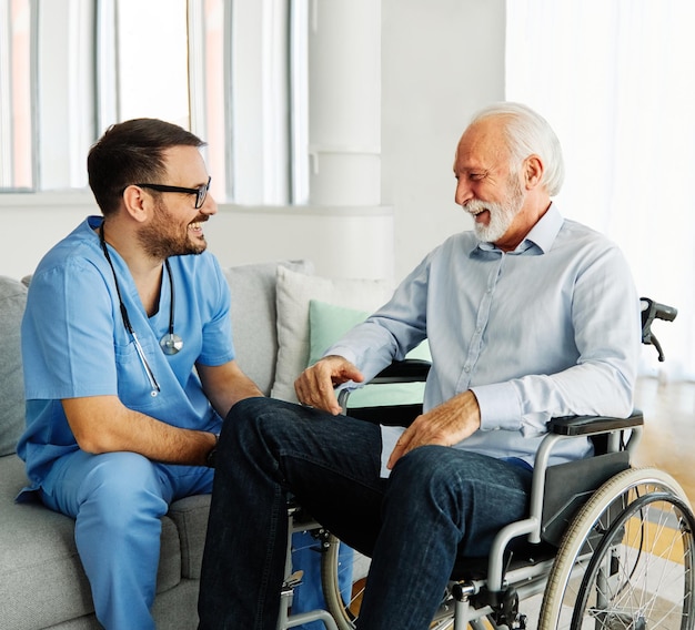 Enfermera médico senior cuidador ayuda asistencia silla de ruedas casa de retiro enfermería anciano discapacitado discapacidad