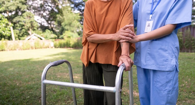 Enfermera o cuidadora y anciana apoyan el servicio de atención médica y el retrato de salud en el hogar Médico fisioterapeuta ayudando y anciano paciente con discapacidad en el hogar