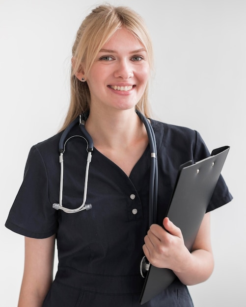 Foto enfermera sonriente con estetoscopio y bloc de notas