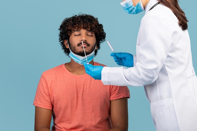 Enfermera sosteniendo hisopo haciendo prueba nasal de coronavirus pcr para hombre