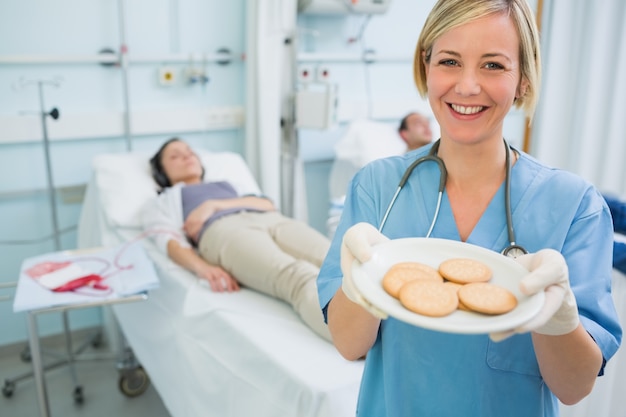 Enfermera sosteniendo un plato de galletas