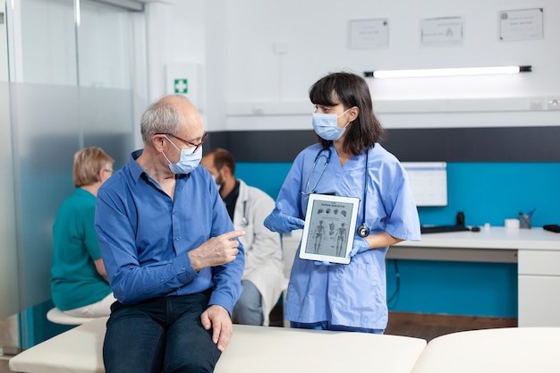 Enfermera sosteniendo tableta digital con esqueleto humano en la imagen