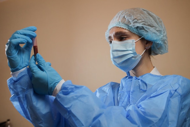 Una enfermera sostiene un tubo de ensayo con una muestra de sangre positiva para el coronavirus pandemia nCoV 2019