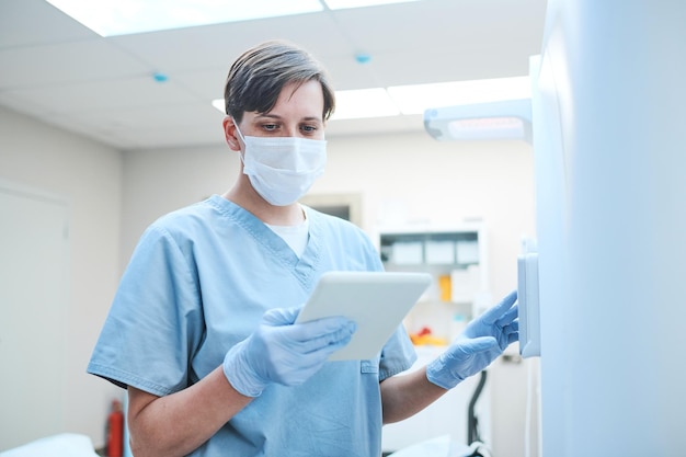 Enfermera con tableta lanzando un escáner de resonancia magnética