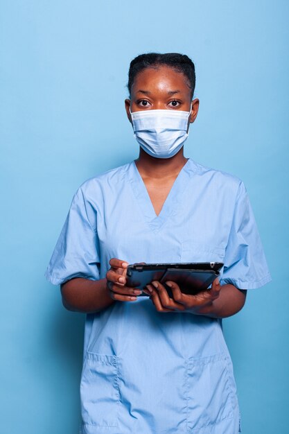 Enfermera terapeuta afroamericana con mascarilla protectora para prevenir la infección por coronavirus