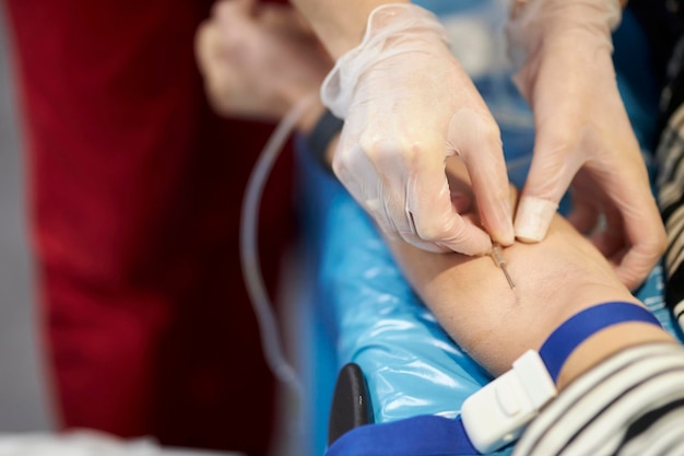 una enfermera toma una muestra de sangre. Mano de un médico con guantes tomando una muestra de sangre de un paciente