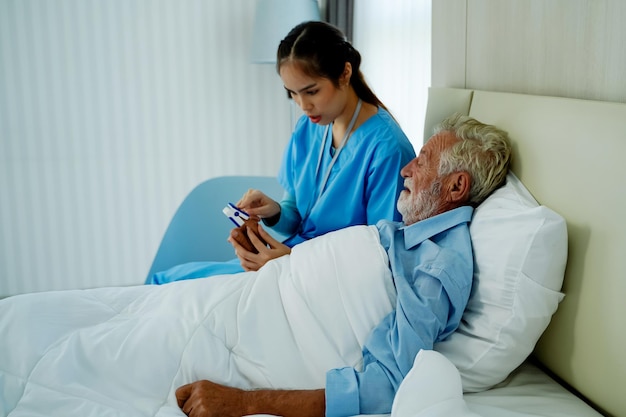 Una enfermera usa un monitor de frecuencia cardíaca paciente anciano Controlar los latidos del corazón comprobar que las personas mayores se retiran en casa Ancianos enfermedad cardíaca concepto de enfermedad cardíaca