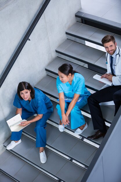 Enfermeras y doctor hablando en escaleras