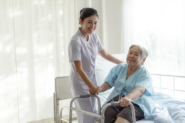 Las enfermeras están bien cuidadas de los pacientes ancianos en la cama del hospital. Los pacientes sienten felicidad concepto médico y de atención médica.