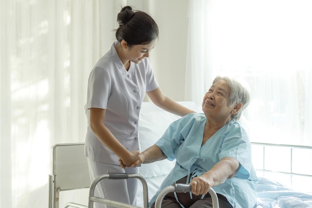 Las enfermeras están bien cuidadas de los pacientes ancianos en la cama del hospital. Los pacientes sienten felicidad concepto médico y de atención médica.