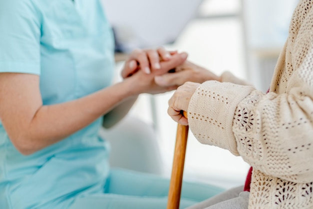 Foto las enfermeras de la mano sosteniendo a las mujeres de edad avanzada de la mano con un bastón y las enfermeras de las manos sosteniendo pastillas que la mujer de edad avanzado