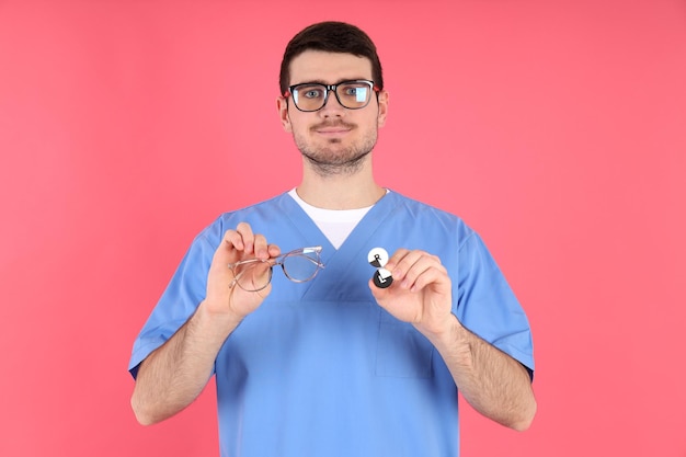 Enfermero tiene gafas y lentes sobre fondo rosa