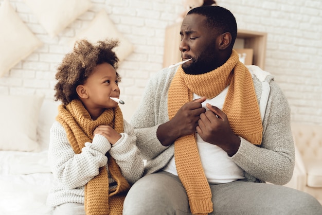 Enfermo americano de padre e hija con la temperatura.