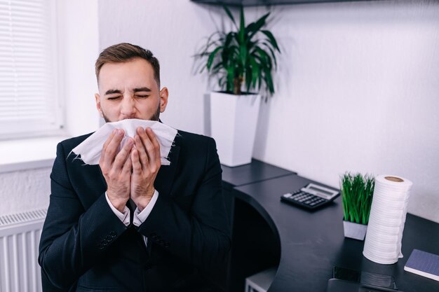 Enfermo en el trabajo joven tiene alergia a la gripe estornudos soplando corriendo n