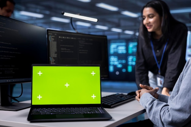 Enfocarse en el cuaderno de pantalla verde utilizado por los administradores del centro de datos en un fondo borroso