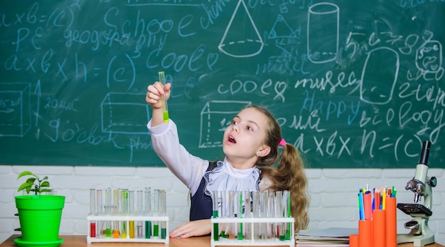 Enfoque interesante para aprender Niña linda alumna de escuela juega con tubos de ensayo y líquidos de colores Experimento químico escolar Educación escolar Científico futuro Explore e investigue Lección escolar