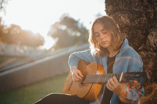 Enfoque de niña tocando la guitarra en el parque