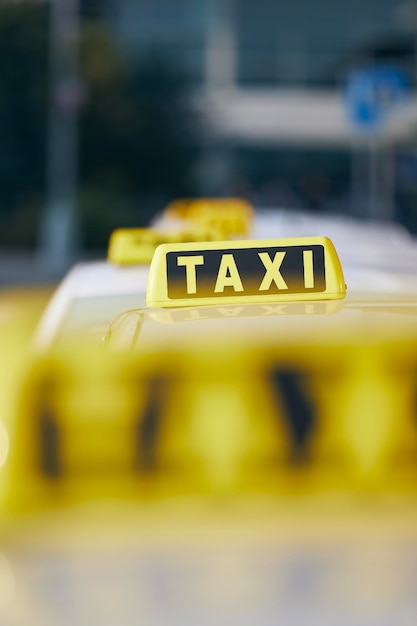 Enfoque selectivo en el cartel de taxi en el coche del techo esperando a un pasajero en la calle de la ciudad