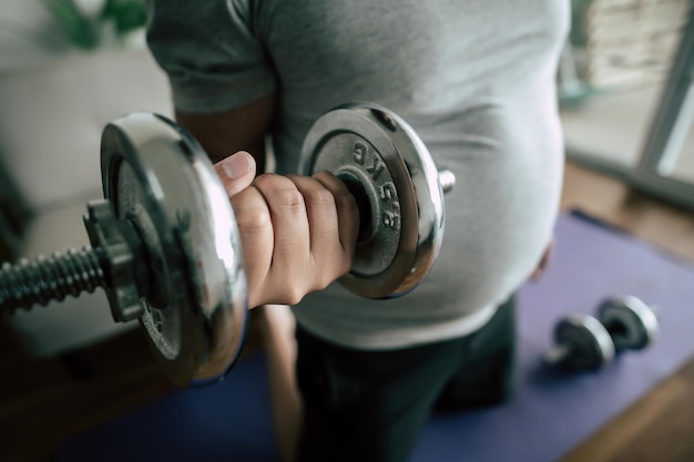 Enfoque selectivo Cierre la mano masculina levantando una mancuerna para hacer ejercicio para un espacio de copia saludable