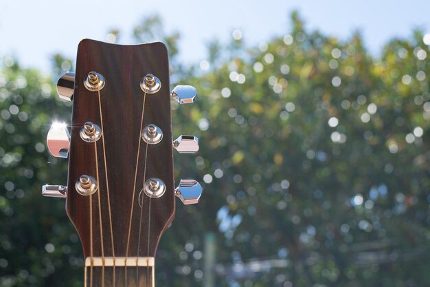 Enfoque selectivo de un clavijero y traste de guitarra acústica al aire libre