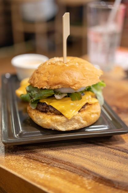 enfoque selectivo deliciosa hamburguesa casera de queso de ternera y verduras en una mesa de madera antigua