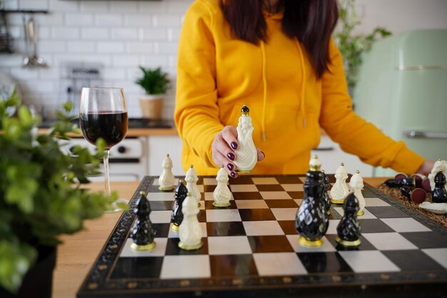 Foto enfoque selectivo del hermoso ajedrez en el tablero de ajedrez primer plano de la parte del cuerpo de una mujer irreconocible jugando en el juego de mesa