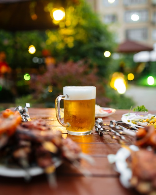 El enfoque selectivo en la jarra de cerveza fría en la mesa servida