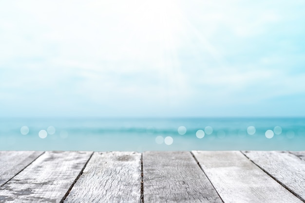 Enfoque selectivo de la mesa de madera vieja con un hermoso fondo de playa para mostrar su producto.