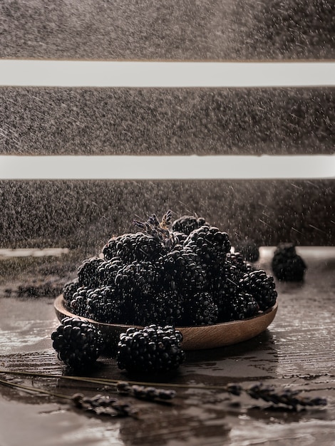 Enfoque selectivo, moras en una placa de madera. sobre un fondo oscuro, copyspace. Clave baja