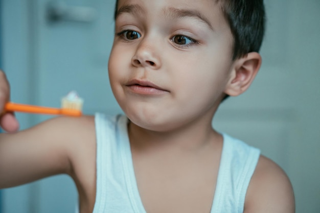 Enfoque selectivo del niño emocionado mirando el cepillo de dientes con pasta de dientes