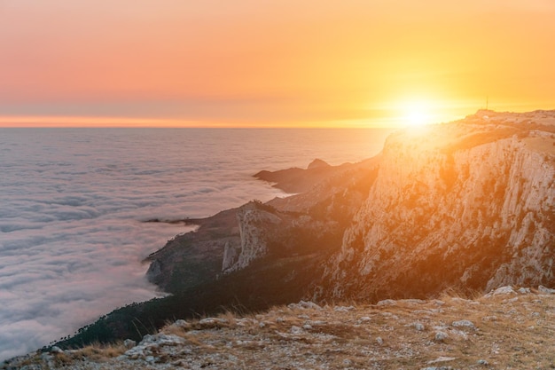 Enfoque selectivo puesta de sol en llamas rojas en lo alto de las montañas sobre las nubes copia espacio el concepto de