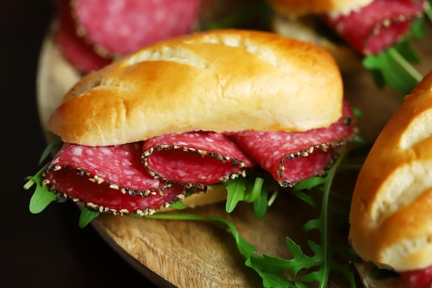 Enfoque selectivo Sándwiches de macro salami con rúcula y mostaza en una tabla de madera