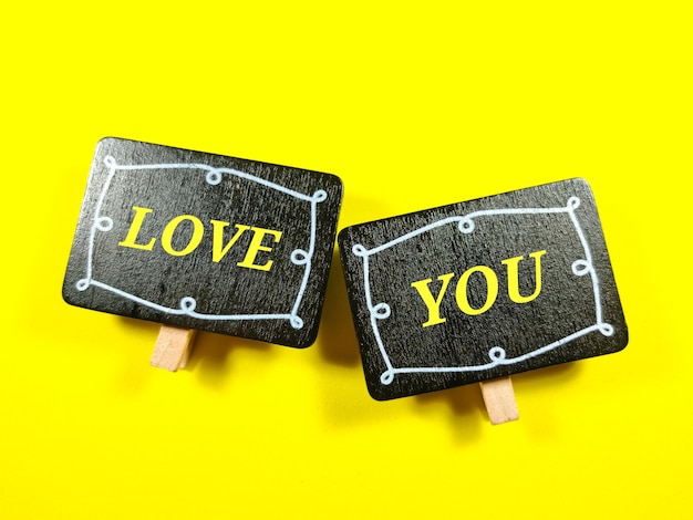Enfoque selectivo Tablero de madera con la palabra LOVE YOU sobre fondo amarillo