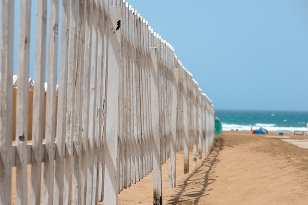 Enfoque selectivo de una valla de madera en la playa con el mar de fondo