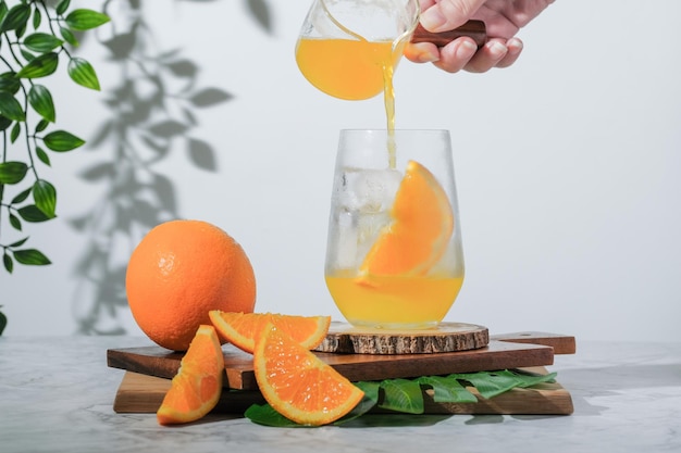 El enfoque selectivo vertiendo soda de naranja en un vaso sobre fondo blanco el refresco es una bebida fresca de verano en la mañana el jugo de naranja helado es una bebida alternativa para una vida saludable