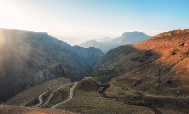 Enfoque suave. Carretera sinuosa escénica en el valle rojo. Vista del atardecer de camino sinuoso en paso de alta montaña.