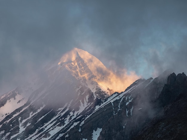 Enfoque suave Montañas místicas Paisaje atmosférico en la cima soleada de la cordillera sobre nubes bajas gruesas Hermoso paisaje alpino con cordillera sobre nubes oscuras y densas