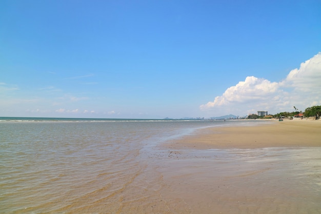 Enfoque suave de las olas batir en la playa con arena y cielo azul con reflejo.