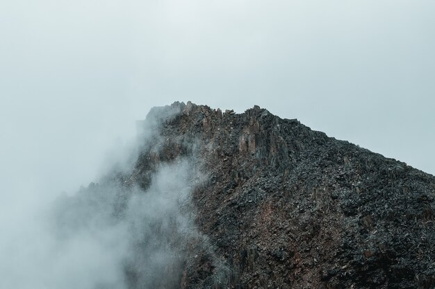 Enfoque suave. Sombras de la montaña de terror. Niebla espectacular entre montañas rocosas gigantes. Vista atmosférica fantasmal al gran acantilado. Nubes bajas y hermosas rocosas. Lugar misterioso paisaje minimalista.