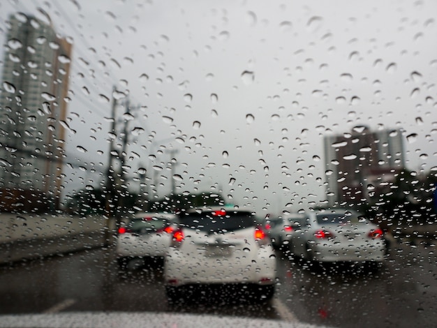 Engarrafamento em dia chuvoso com pingos de chuva em vidros de carro