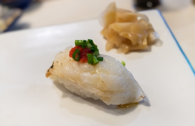 Engawa sushi o aleta de pescado plano con arroz.